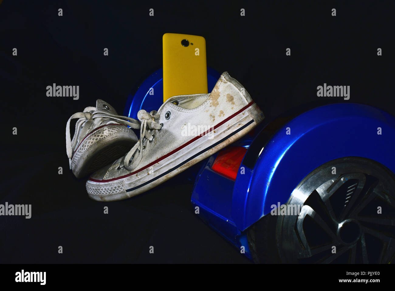 dirty and used sneakers on electric scooter Stock Photo