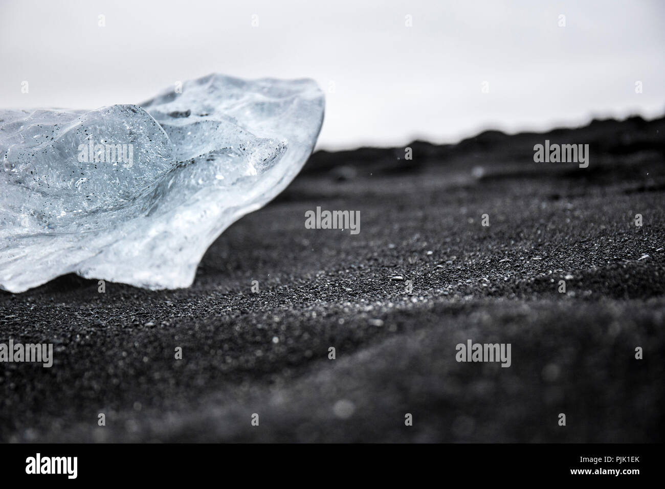 Ice block from the glacier on deep black sand in Jökulsárlón, Iceland Stock Photo