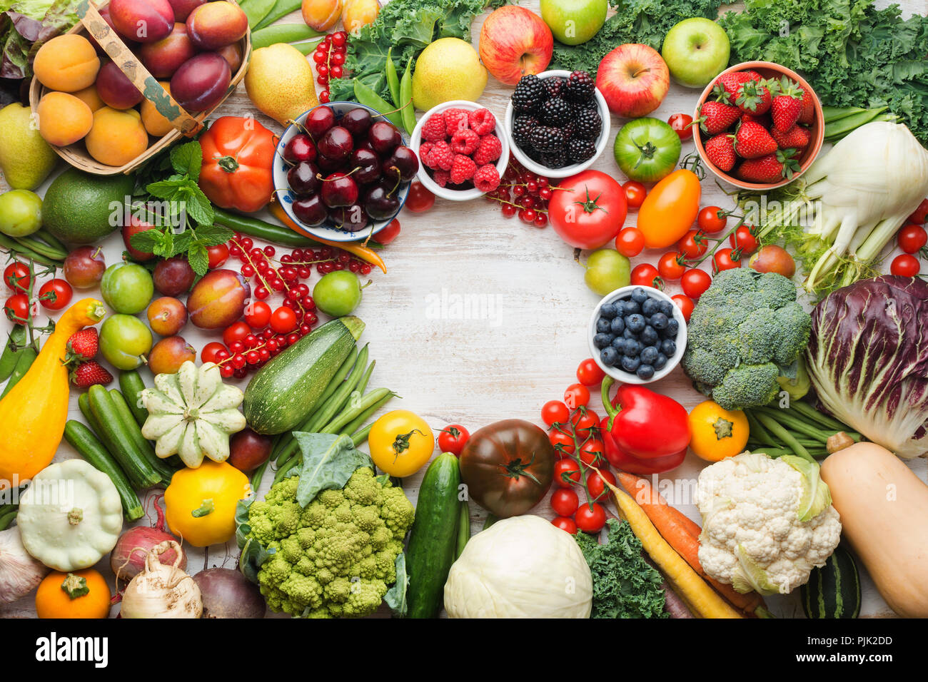 Healthy summer fruits vegetables berries arranged in a circle frame ...