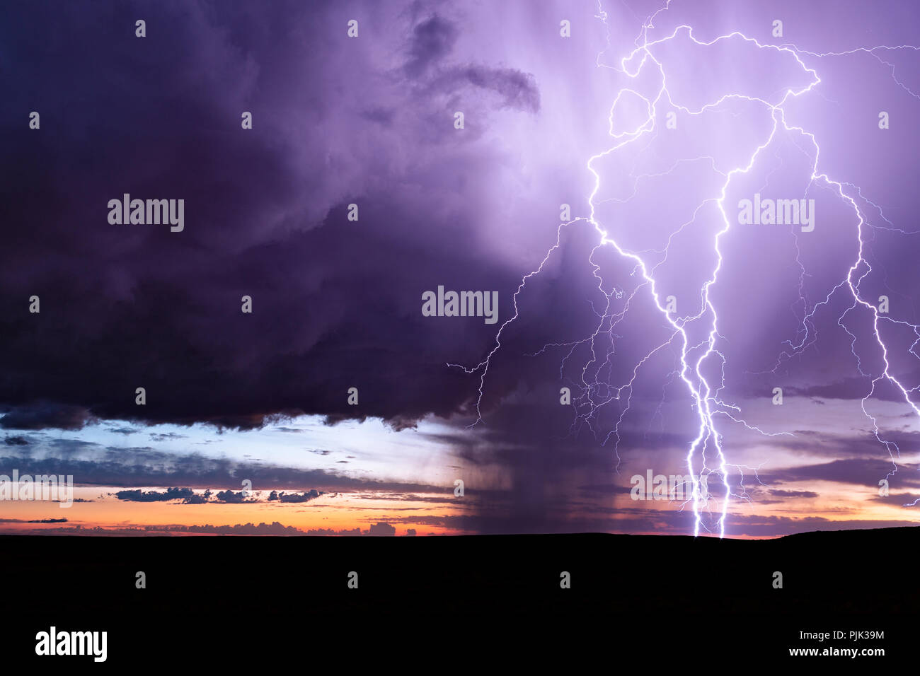 Dramatic sky with lightning bolts and storm clouds at sunset near Holbrook, Arizona Stock Photo