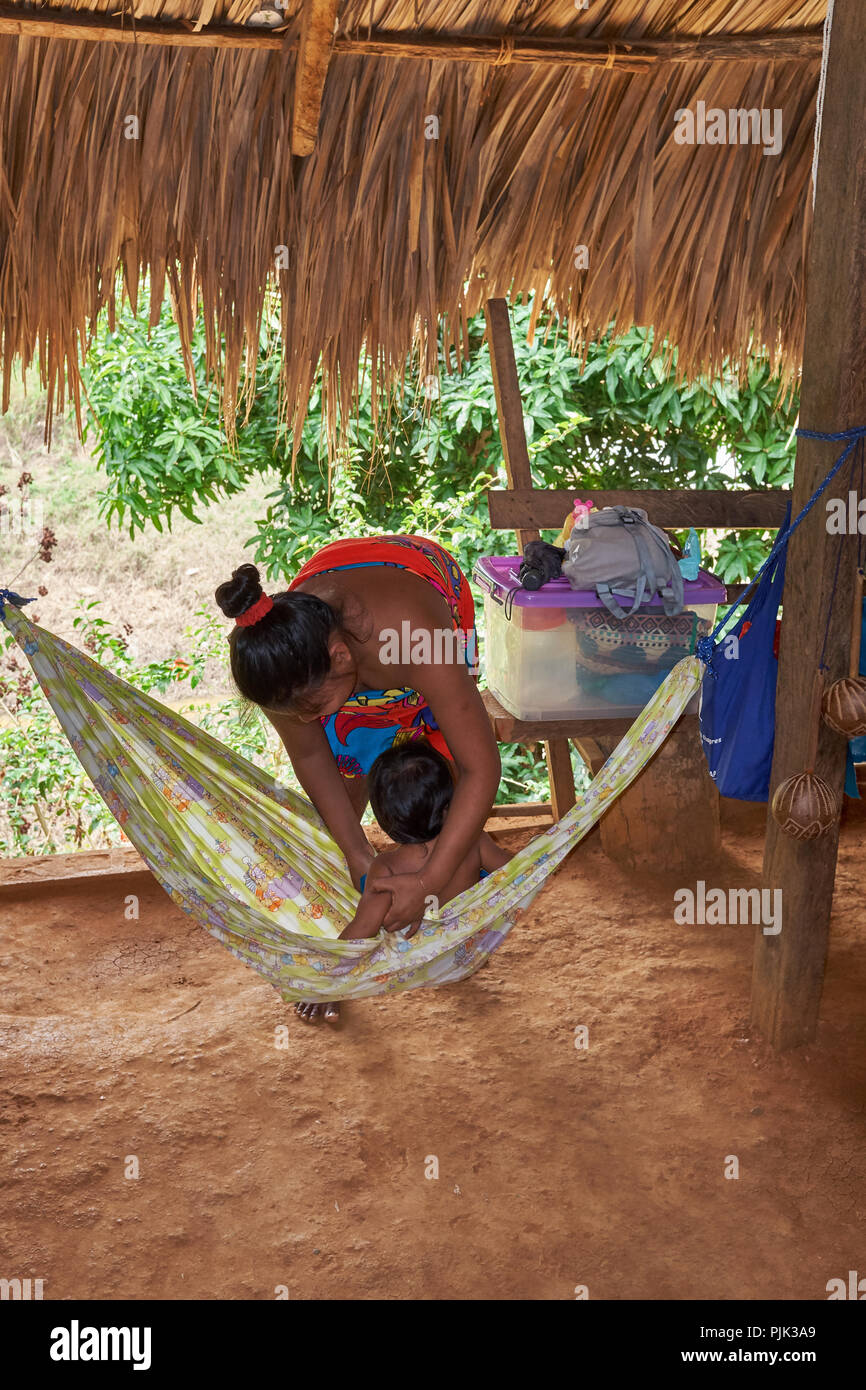 Chagres National Park, Panama - April 22, 2018: Native Embera woman singing to her baby in a hamak Stock Photo