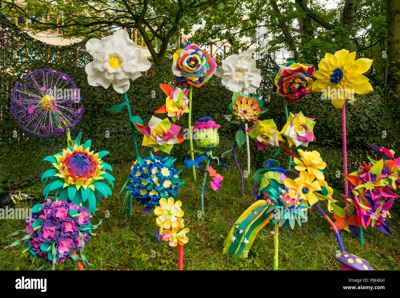 Colourful fake giant flowers stuck in grass, decorations, George Square Gardens during festival time, Edinburgh, Scotland, UK Stock Photo