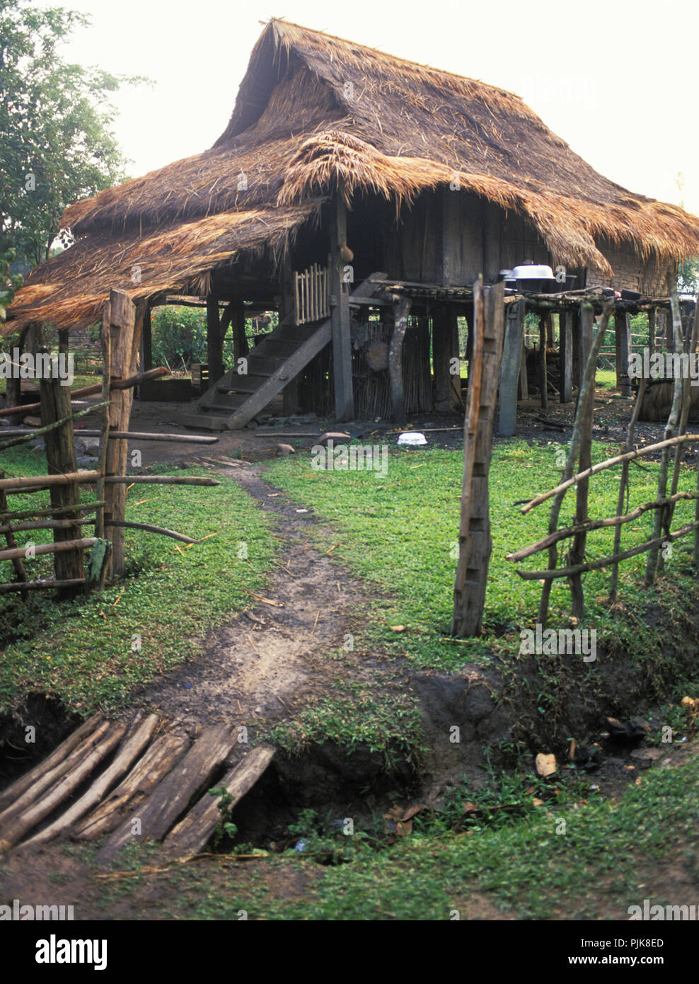 A bamboo thatched roof stilt house in a village in Phonsavan Stock Photo