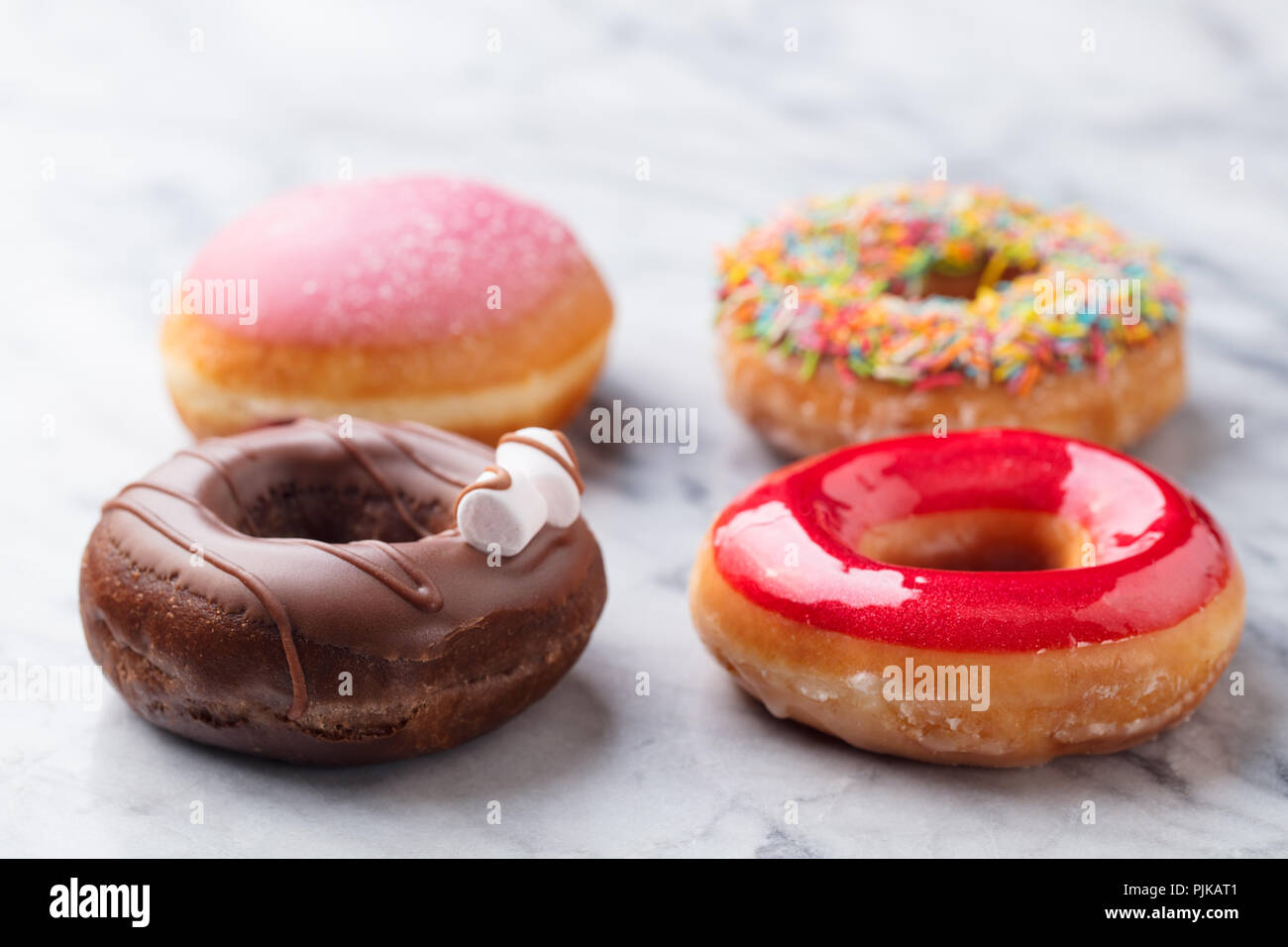 Donuts assortment with colorful glaze on marble background Stock Photo ...