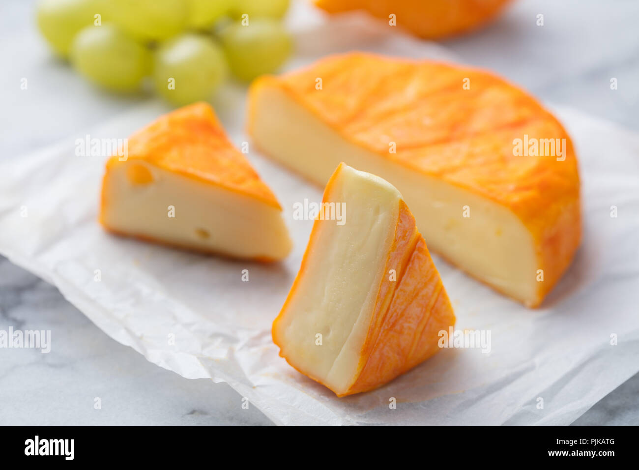 Cheese with washed orange rind. French or German. Marble table