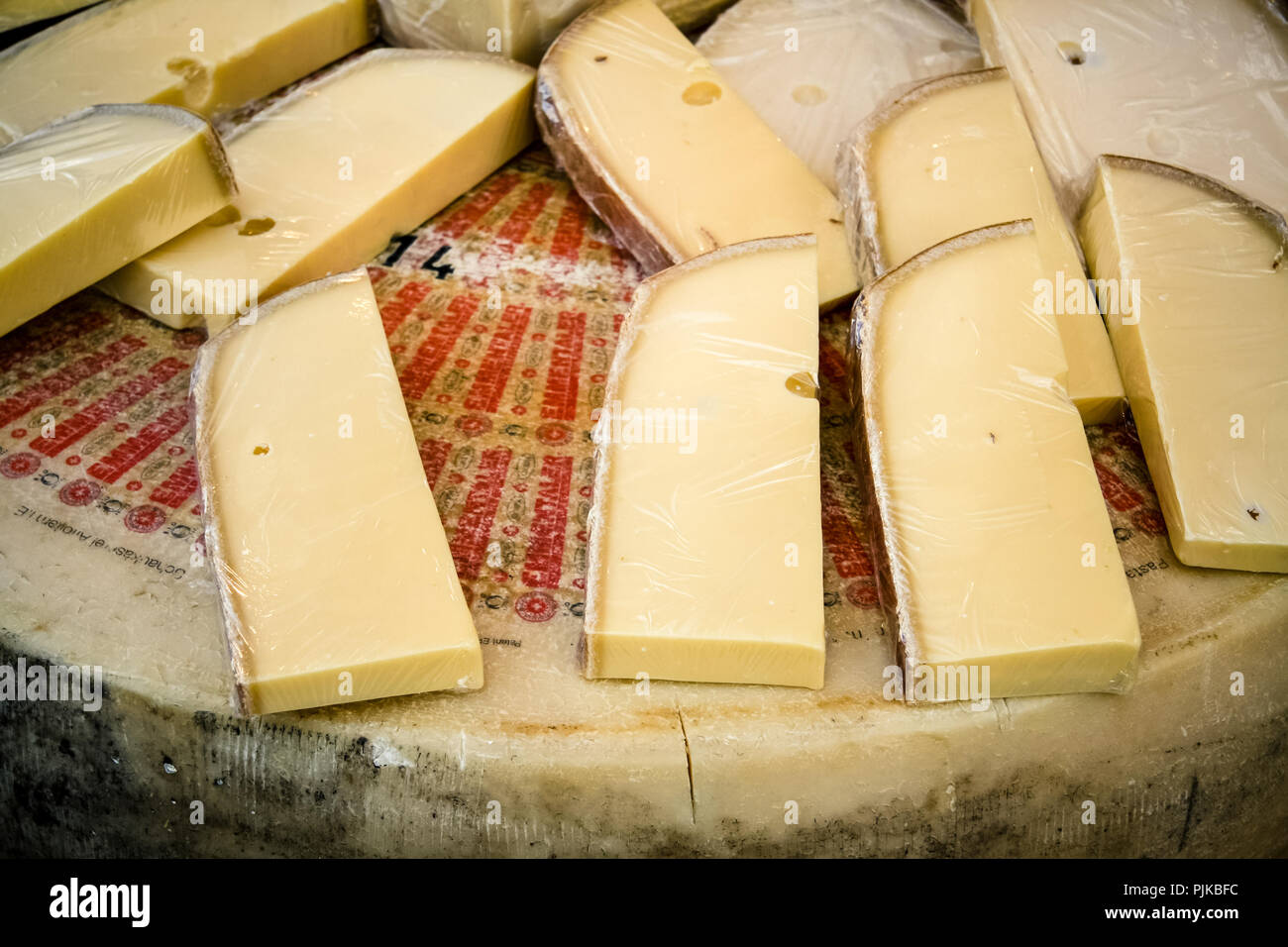Emmentaler cheese wheel and slices on market stand Stock Photo Alamy