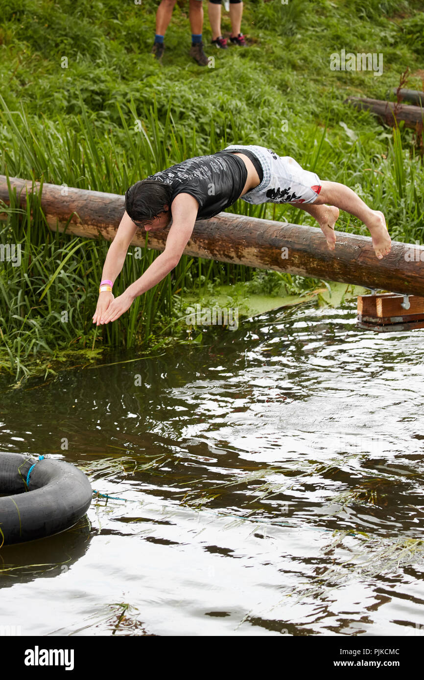 Man diving into water on a river obstacle course at The Lowland Games, Thorney, Somerset, England Stock Photo