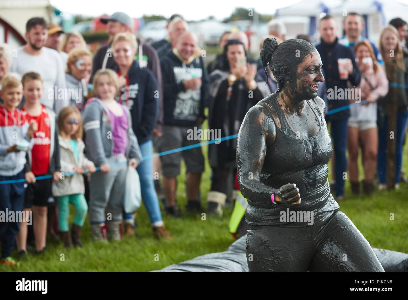 Woman standing covered in mud at a mud wrestling contest at The Lowland Games, Thorney, Somerset, England Stock Photo