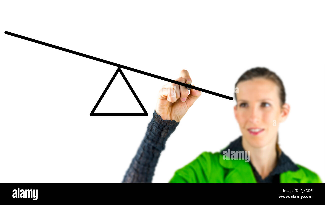 Woman drawing a seesaw on a virtual screen in a conceptual image of equilibrium and balancing opposing interests or forces Stock Photo