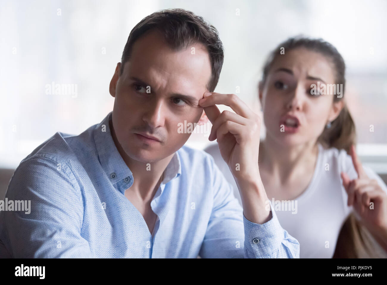 Bothering woman lecturing annoyed husband during fight Stock Photo