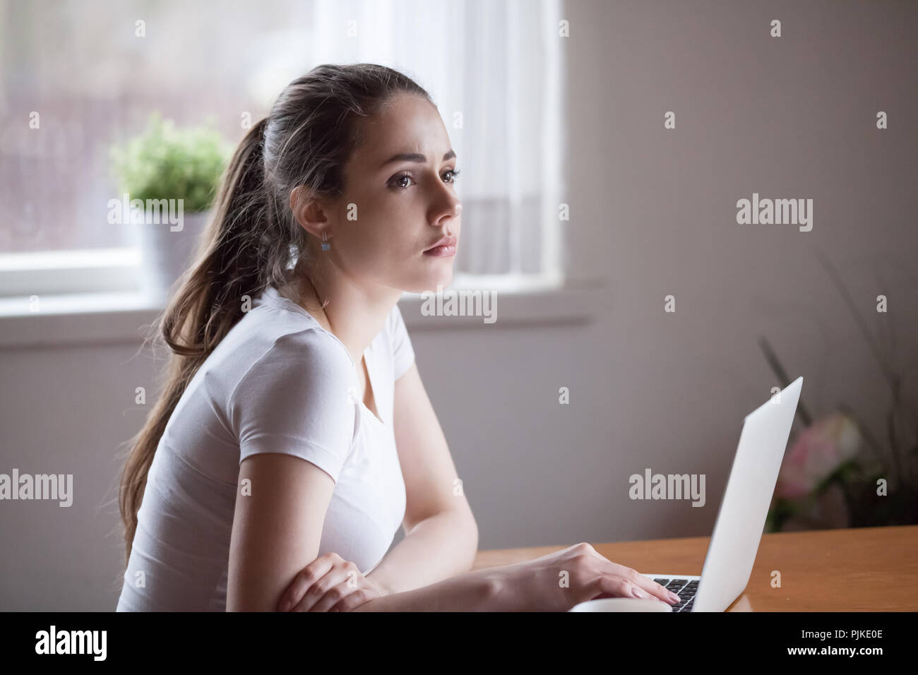 Upset girlfriend waiting for message from lover on laptop  Stock Photo