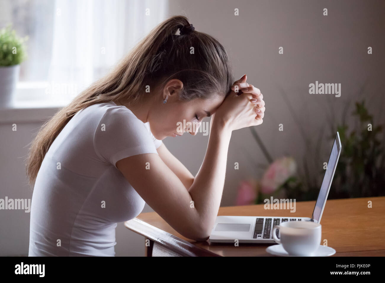 Upset young woman feel down receiving negative message Stock Photo