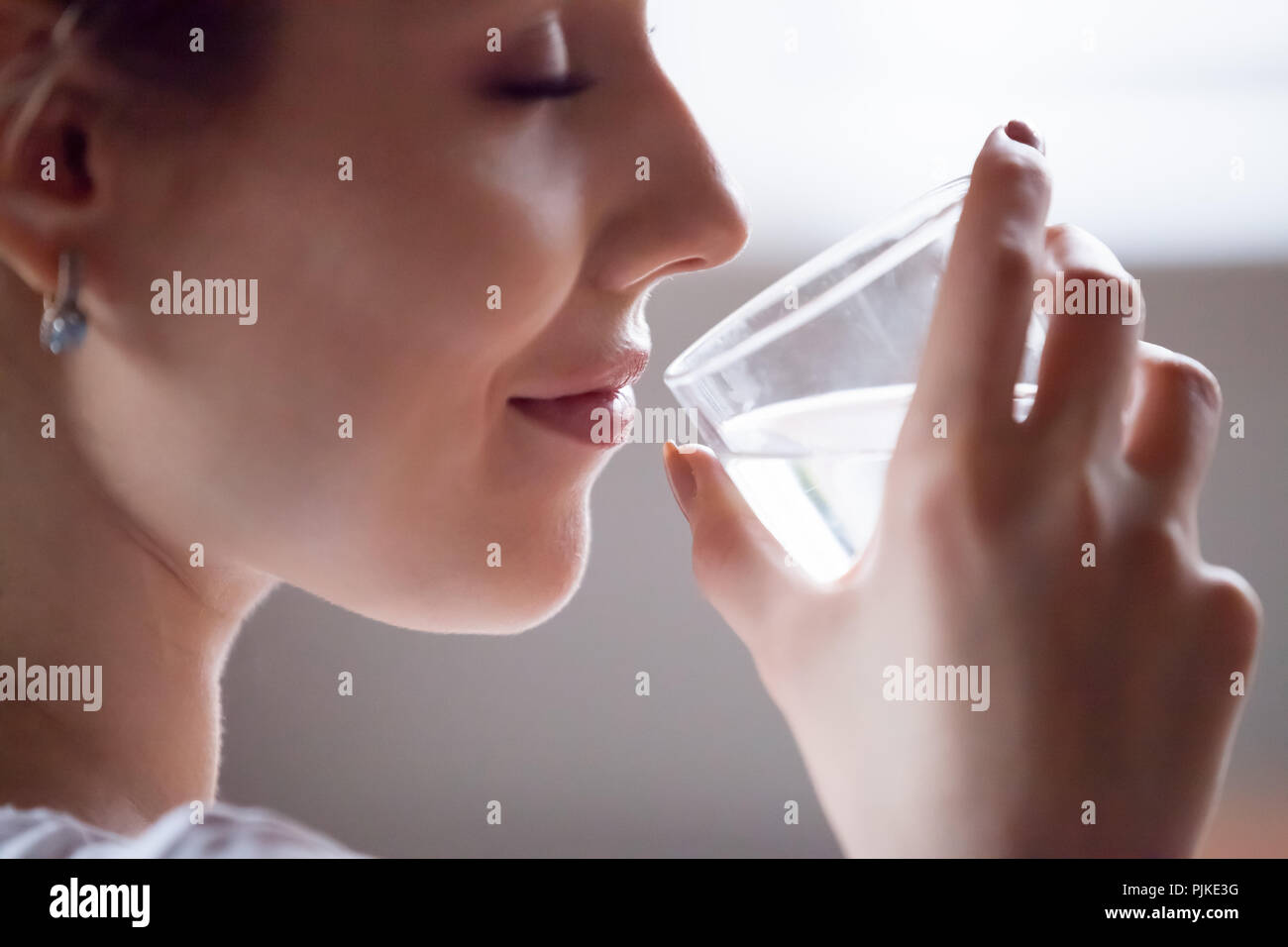 Close up of thirsty pretty female enjoying pure water Stock Photo