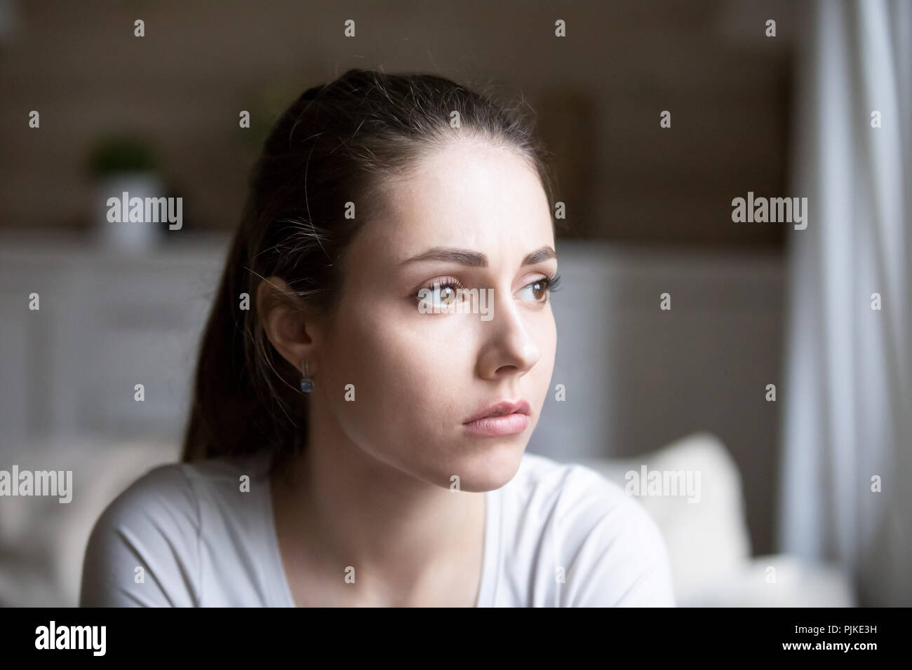Sad woman looking far away thinking about personal problems Stock Photo
