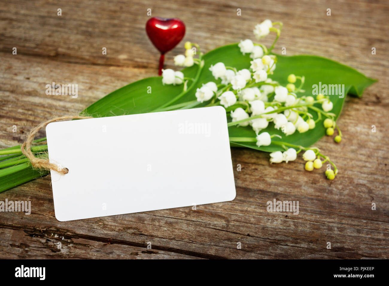 Lily of the valley with heart and card on wood hires stock photography