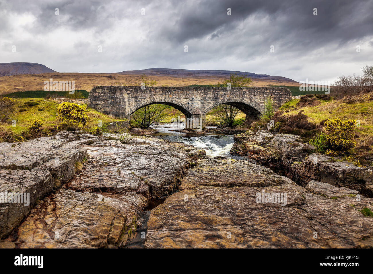 An old stone bridge over a creek in the scottish highlands Stock Photo