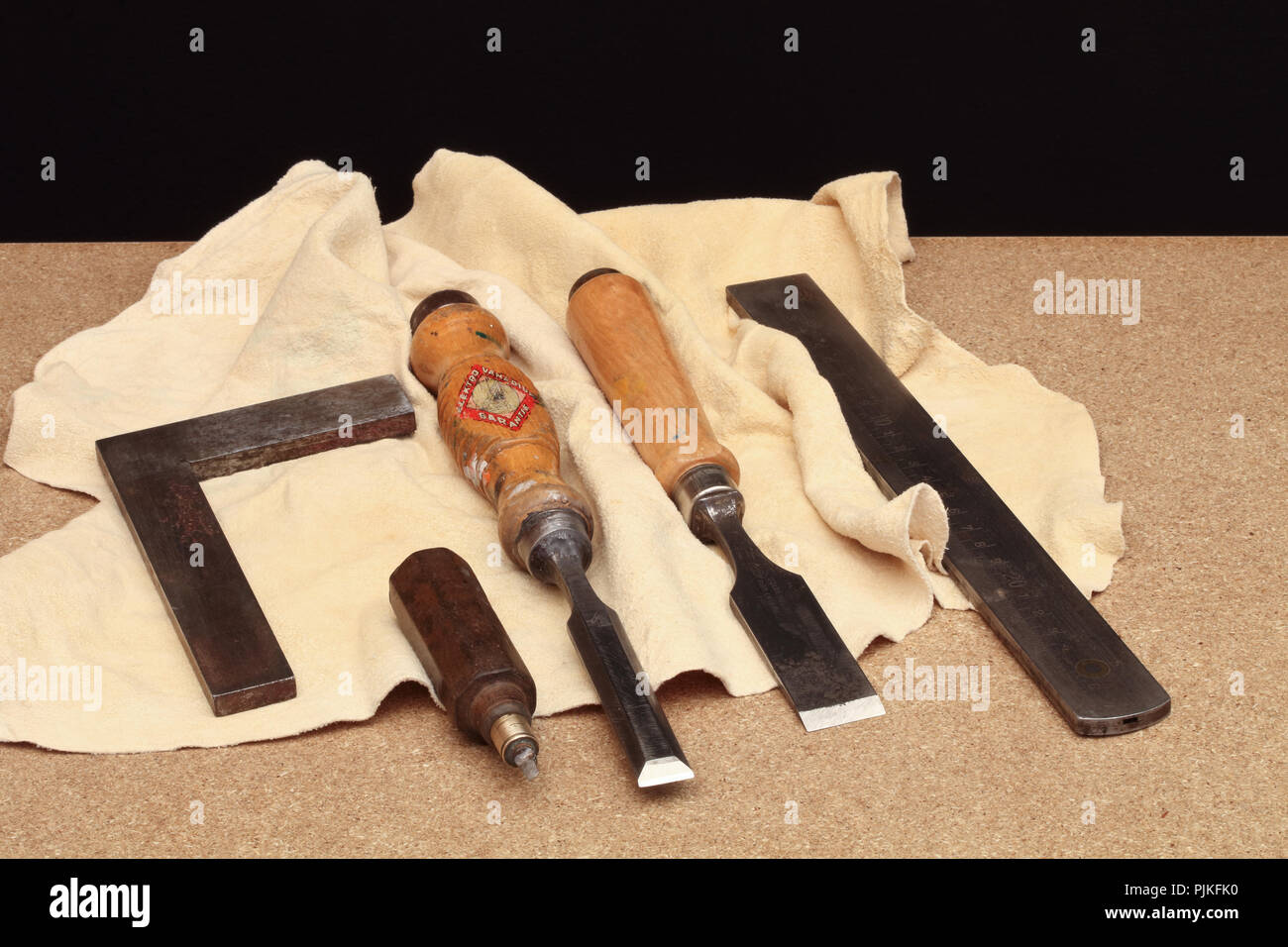 Still life with old tools on the table with leather –wooden chisels, gauge and steel angle Stock Photo