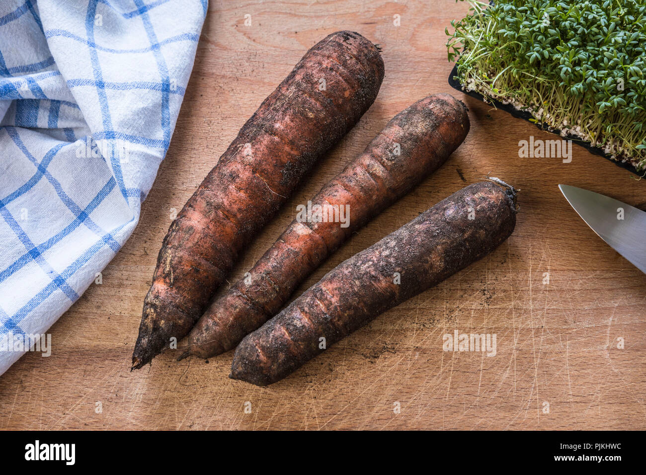 three carrots on cutting board Stock Photo