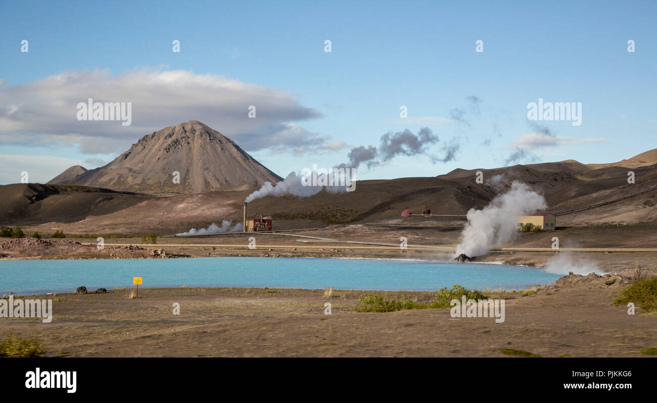 Iceland, Geothermal Power Station, Myvatn area, steaming chimneys, blue lake, volcanic cone in the background Stock Photo