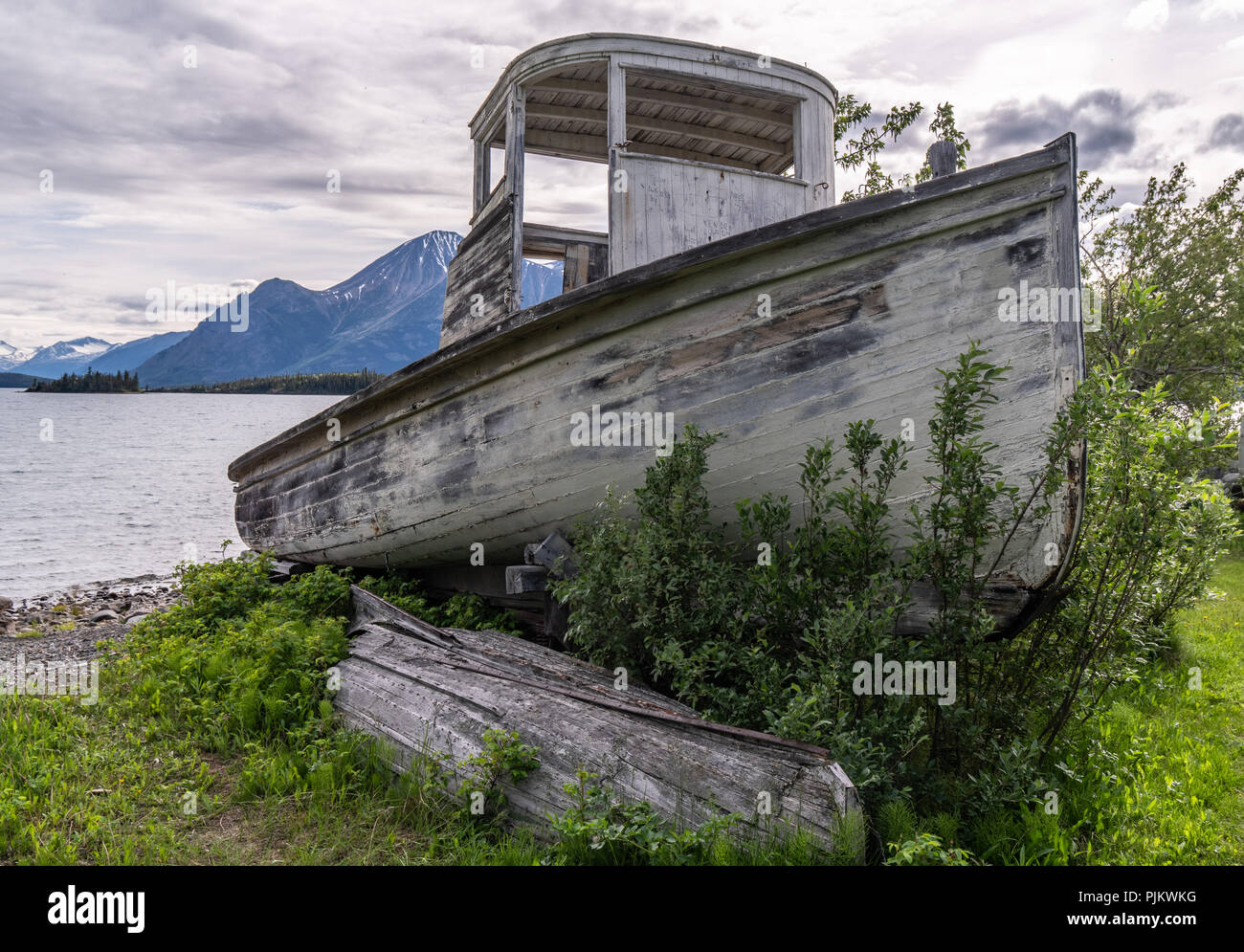 Atlin, once a busy mining comunity turned into tourist atraction, now it is a quite community on the shore of Atlin lake. Here an old boat resting on  Stock Photo