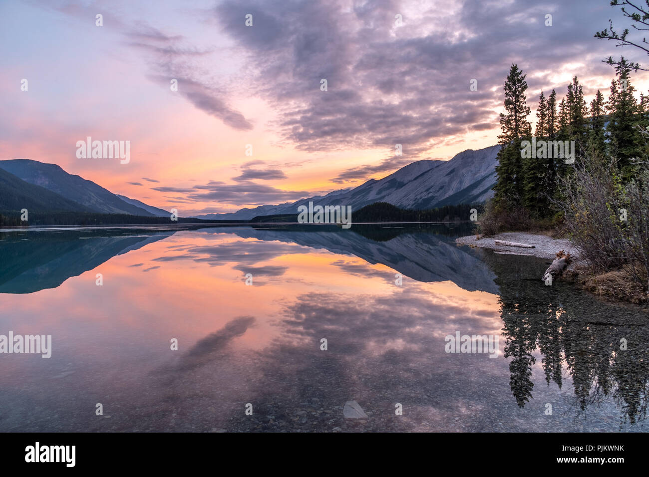 Reflection of early sunrise glowing light on Moncho Lake in the Northern Canadian Rockies Stock Photo