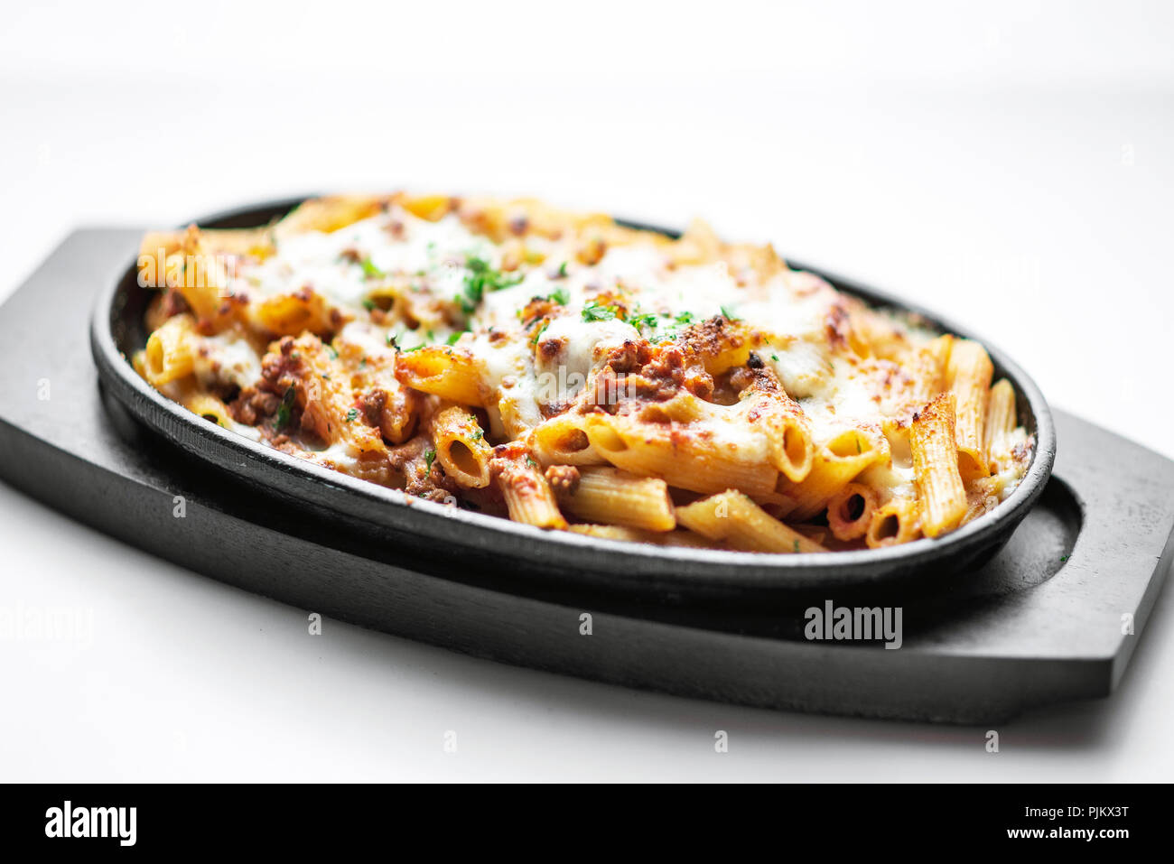 gourmet oven baked fresh pasta penne bolognese and mozzarella cheese dish Stock Photo