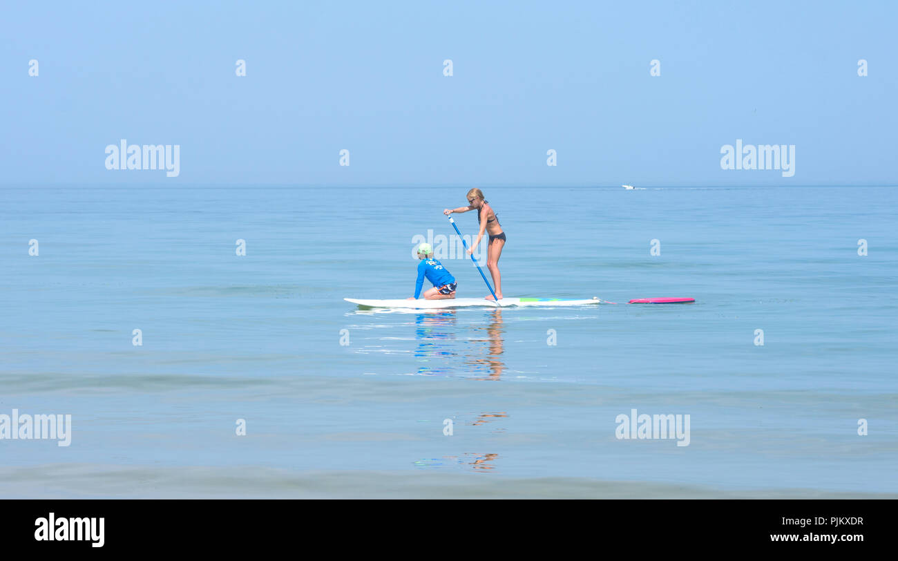 Two girls on a paddleboard in Dennis, Massachusetts, on Cape Cod Stock Photo
