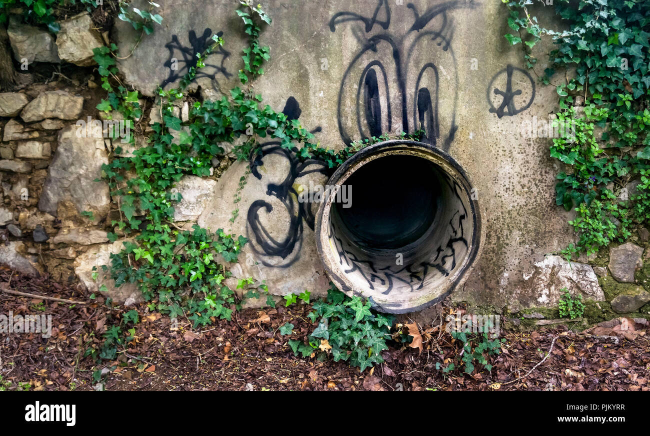 Sewer pipe with graffiti in spring at Bize Minervois Stock Photo