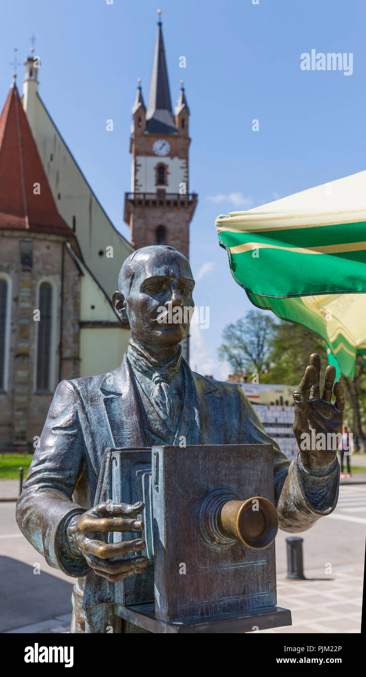 The bronze statue of the photographer Alexandru Rosu, 1854-1943, behind the Evangelical Church, built 1520-1563, Bistrita, Bistrita, Beszterce, Transylvania, Romania, Europe Stock Photo