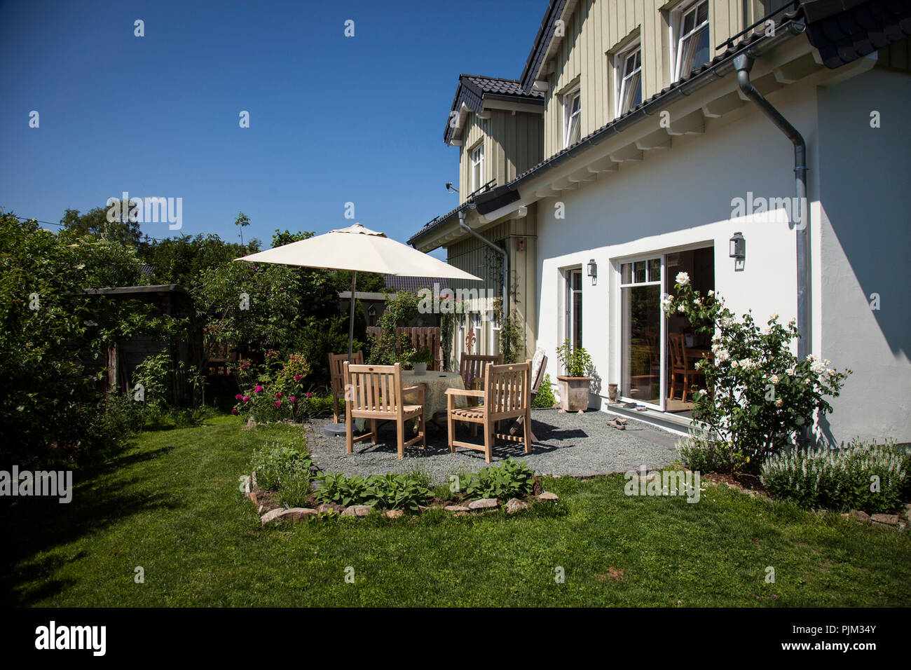 Natural garden and patio in front of an ecological wooden house Stock Photo