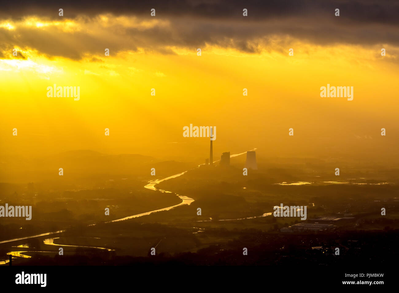 STEAG coal power plant Bergkamen on the Datteln-Hamm Canal in the evening light, smog, haze, hazy weather, inversion weather, back light, golden light, industrial romance, sun shining through cloud hole on the power plant, Bergkamen, Ruhr area, North Rhine-Westphalia, Germany Stock Photo