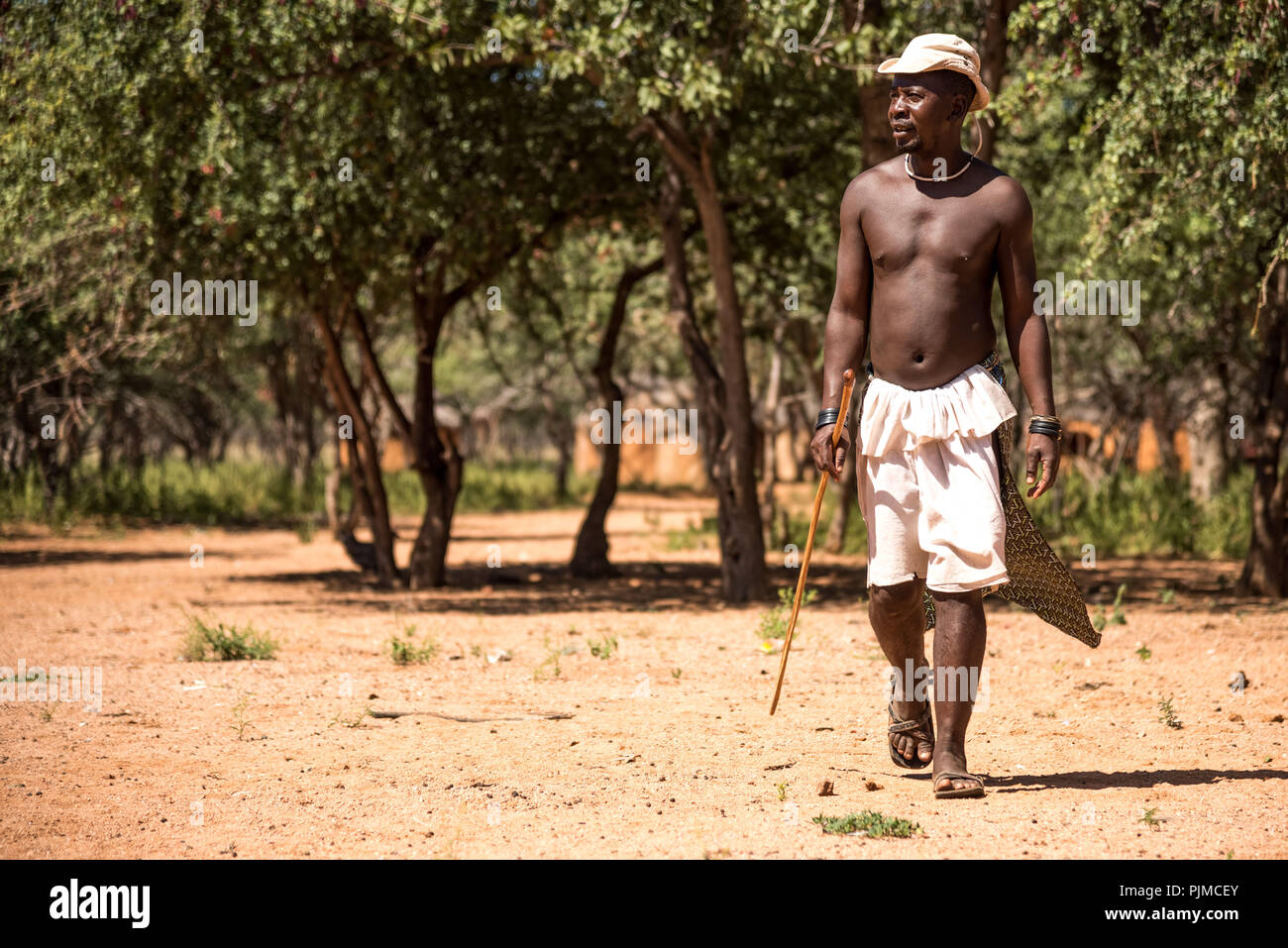 A Himba man was away with the cattle herds and returned to the village Stock Photo