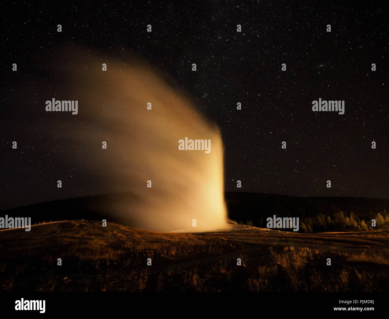 Old Faithful geyser Erupting at Night Stock Photo