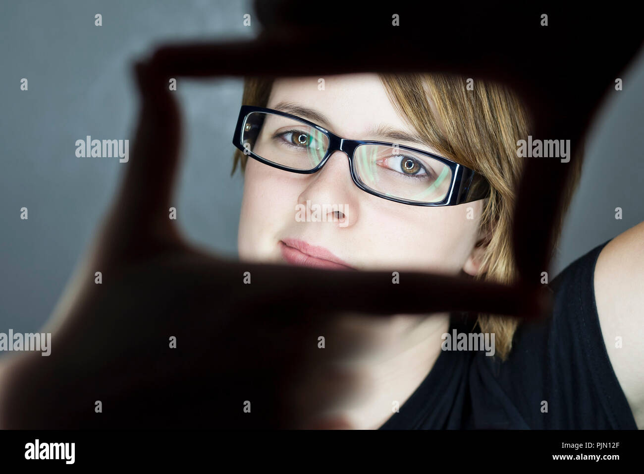 smiling teenage girl making a frame with her hands Stock Photo