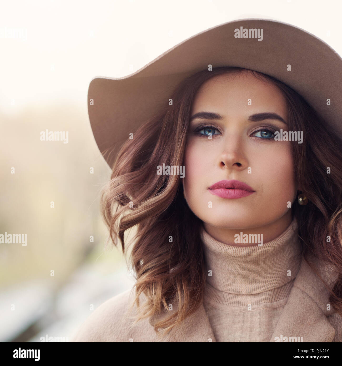 Beautiful woman face outdoor. Perfect female model with curly hair and makeup, closeup portrait Stock Photo