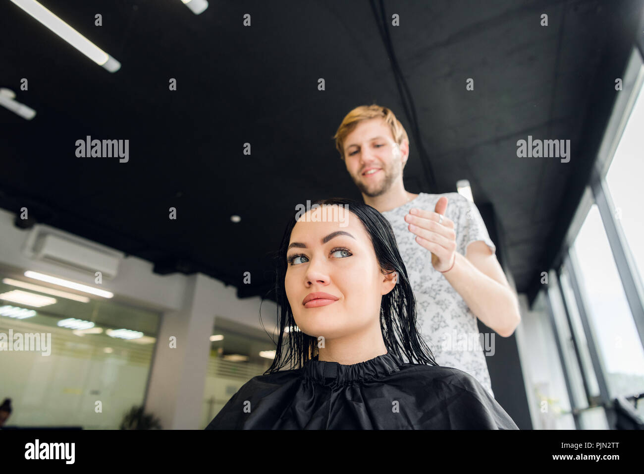 Professional hairdresser discussing female customer preferences in barbershop, choosing new hairdo Stock Photo