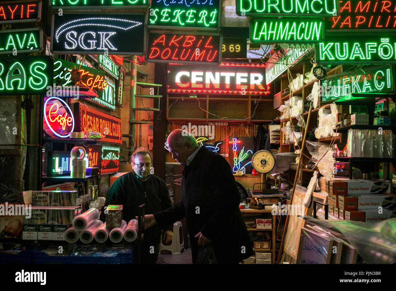 ISTANBUL, TURKEY - DECEMBER 29, 2015: Two Turkish men discussing in a small shop selling neon and led lights for businesses mainly restaurants and caf Stock Photo