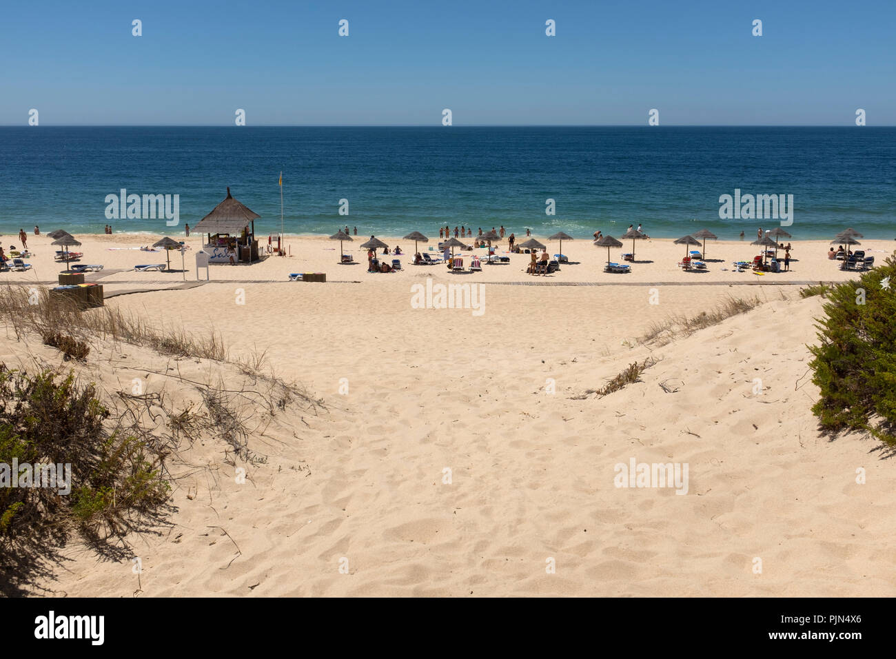Umbrellas and people at Praia do Pego, also known as Pego Beach, Carvalhal, Portugal, during summer Stock Photo