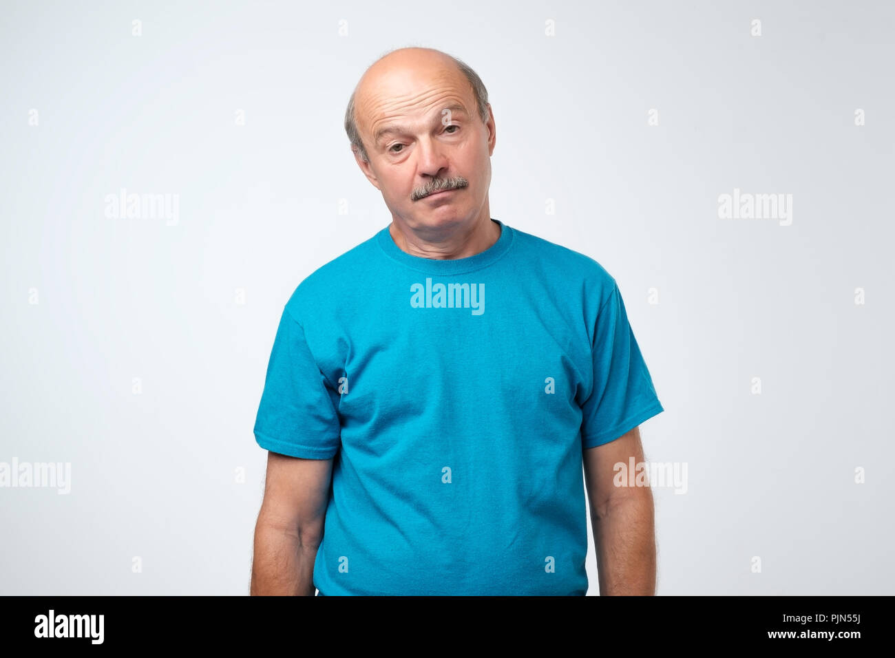 Senior old tired man is hardly openning his eyes. Stock Photo