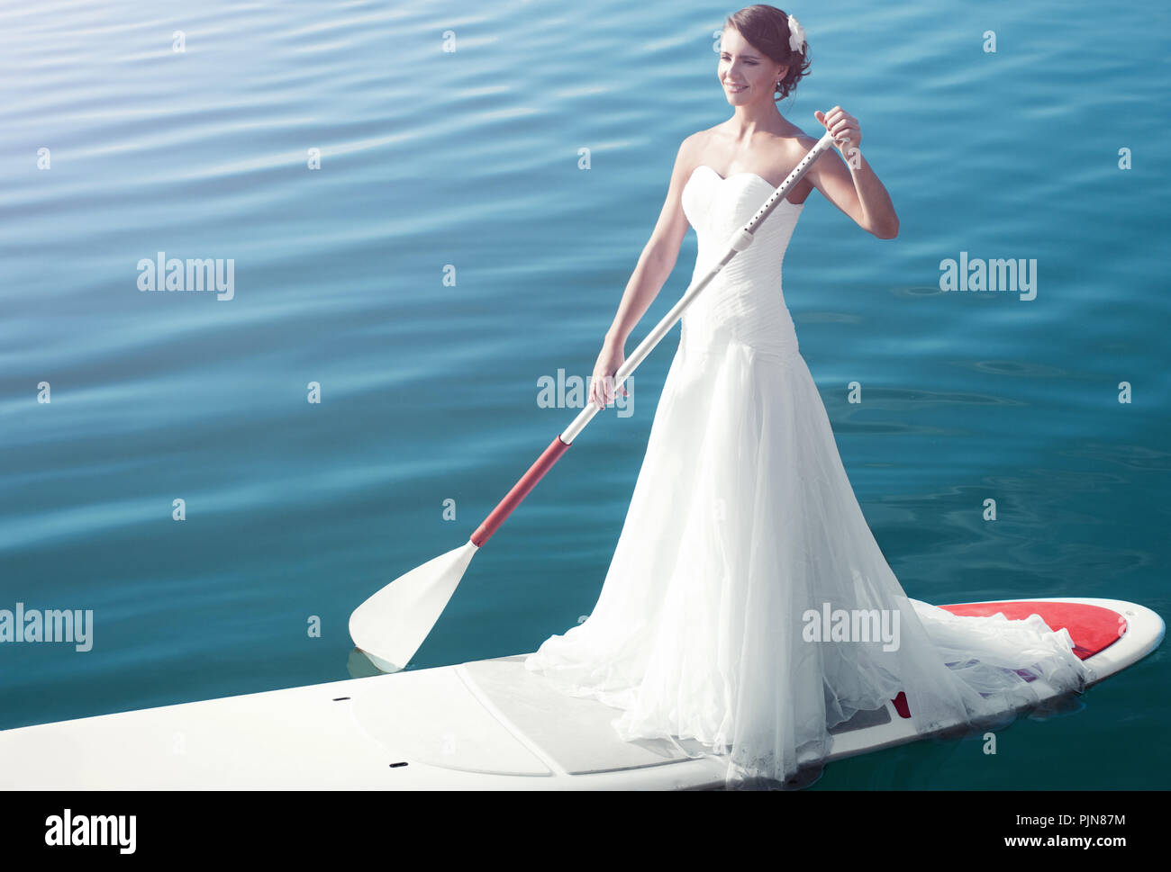 Девушка на лодке в белом платье с веслом
