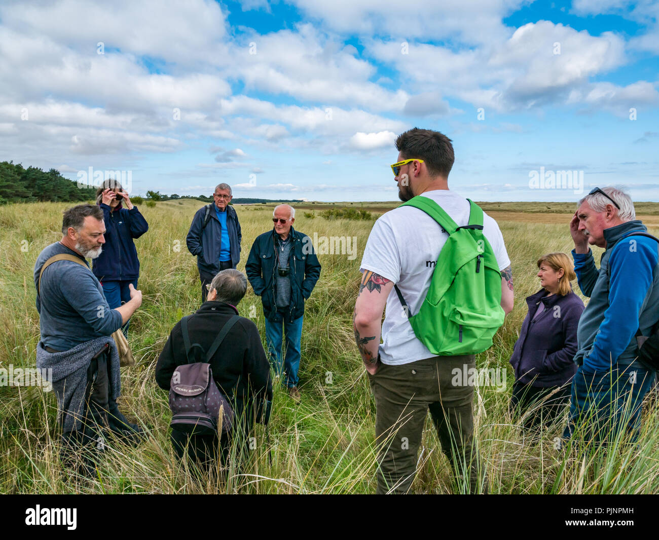 John Muir Country Park, Dunbar, East Lothian, Scotland, UK, 8th September 2018. A small group of people enjoy a walk and talk by David Connelly of East Lothian Council Archaeology Service examining evidence of World War defensive locations during East Lothian Archaeology and Local History Fortnight which takes takes place in September each year, and is part of the annual Scottish Archaeology month. Showing overgrown evidence of First World War trenches in the dune bank Stock Photo
