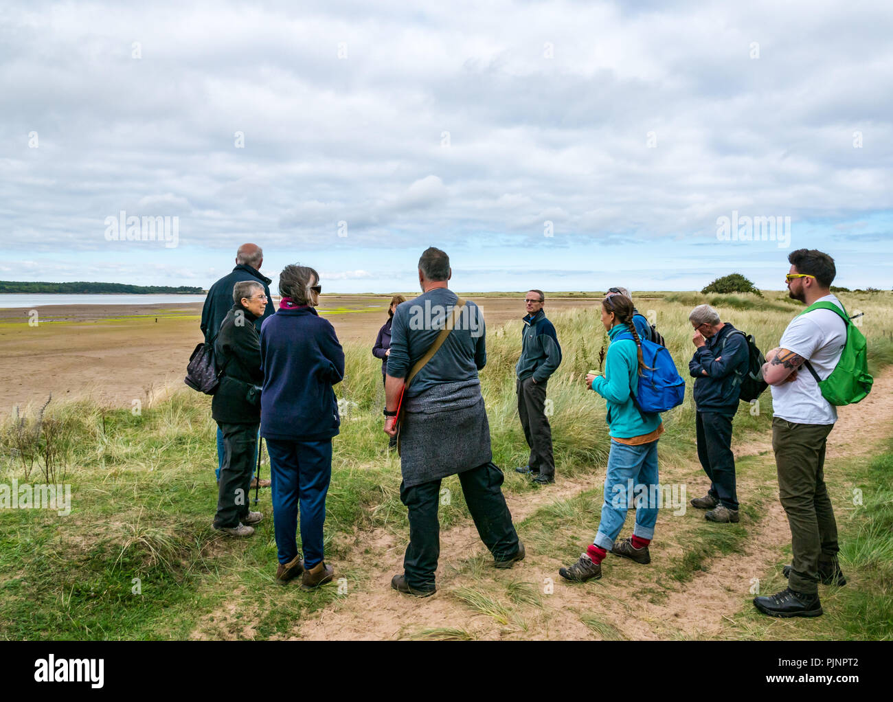 John Muir Country Park, Dunbar, East Lothian, Scotland, UK, 8th September 2018. A small group of people enjoy a walk and talk by David Connelly of East Lothian Council Archaeology Service examining evidence of a rediscovered Neolithic agricultural settlement and World War defensive locations during East Lothian Archaeology and Local History Fortnight which takes takes place in September each year, and is part of the annual Scottish Archaeology month. Hedderwick sands where there are remains of glider poles Stock Photo