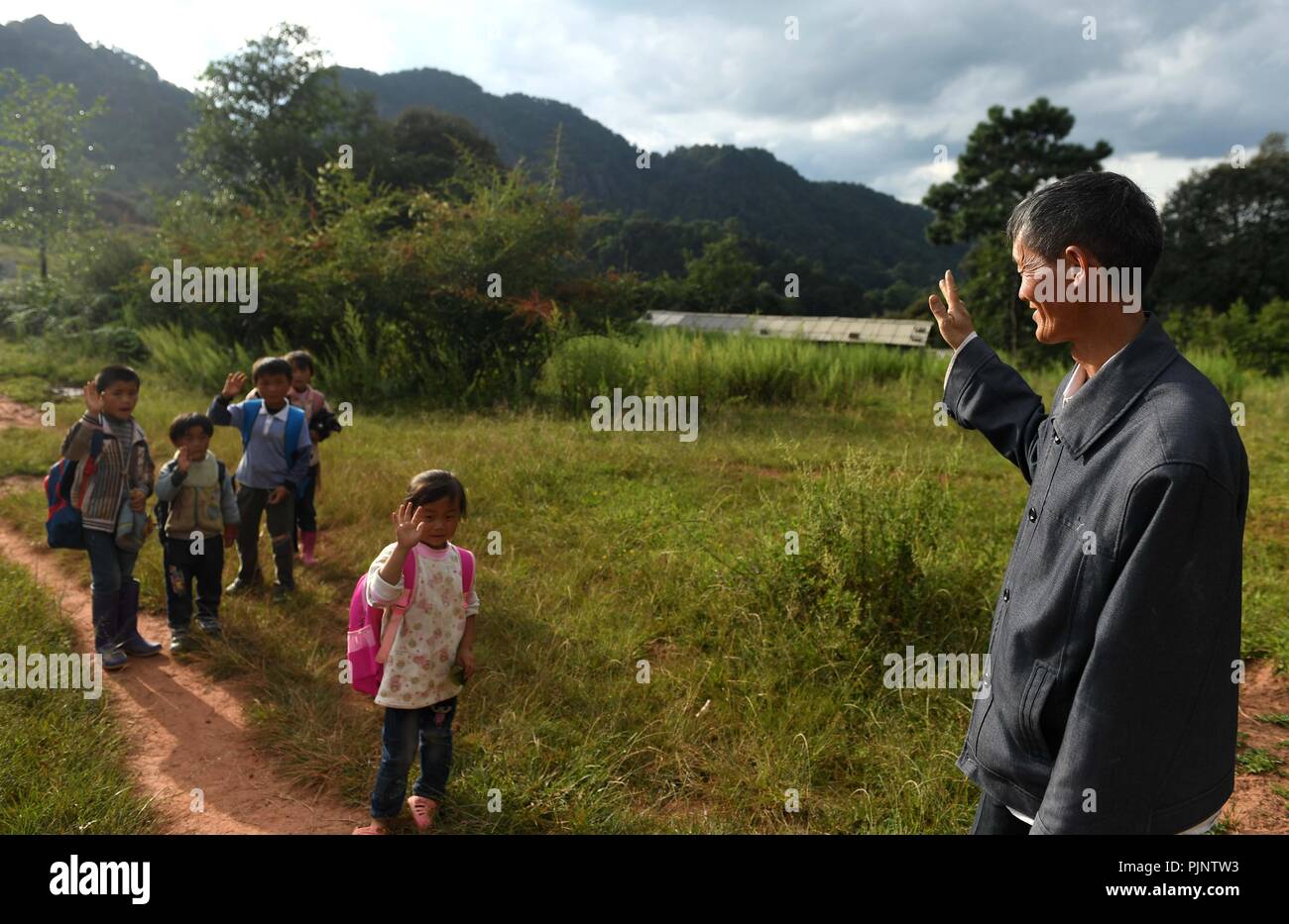 Yunnan Province, China. 8th Sept 2018. Wang Zhengxiang sees off students to the edge of Sanmeng Village of Luquan Yi and Miao Autonomous County, southwest China's Yunnan Province, Sept. 5, 2018. One teacher, eight students, none was and will be given up thanks to rural teacher Wang Zhengxiang. Credit: Xinhua/Alamy Live News Stock Photo
