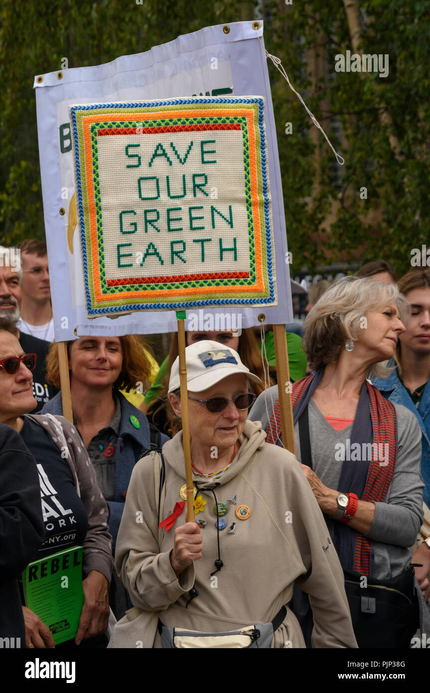 London, UK. 8th September 2018. A woman holds a hand-embroidered placard at the Climate Reality rally in front of Tate Modern, one of thousands around the world demanding urgent action by government leaders to leaders commit to a fossil free world that works for all of us.  community leaders, organisers, scientists, story Credit: Peter Marshall/Alamy Live News Stock Photo