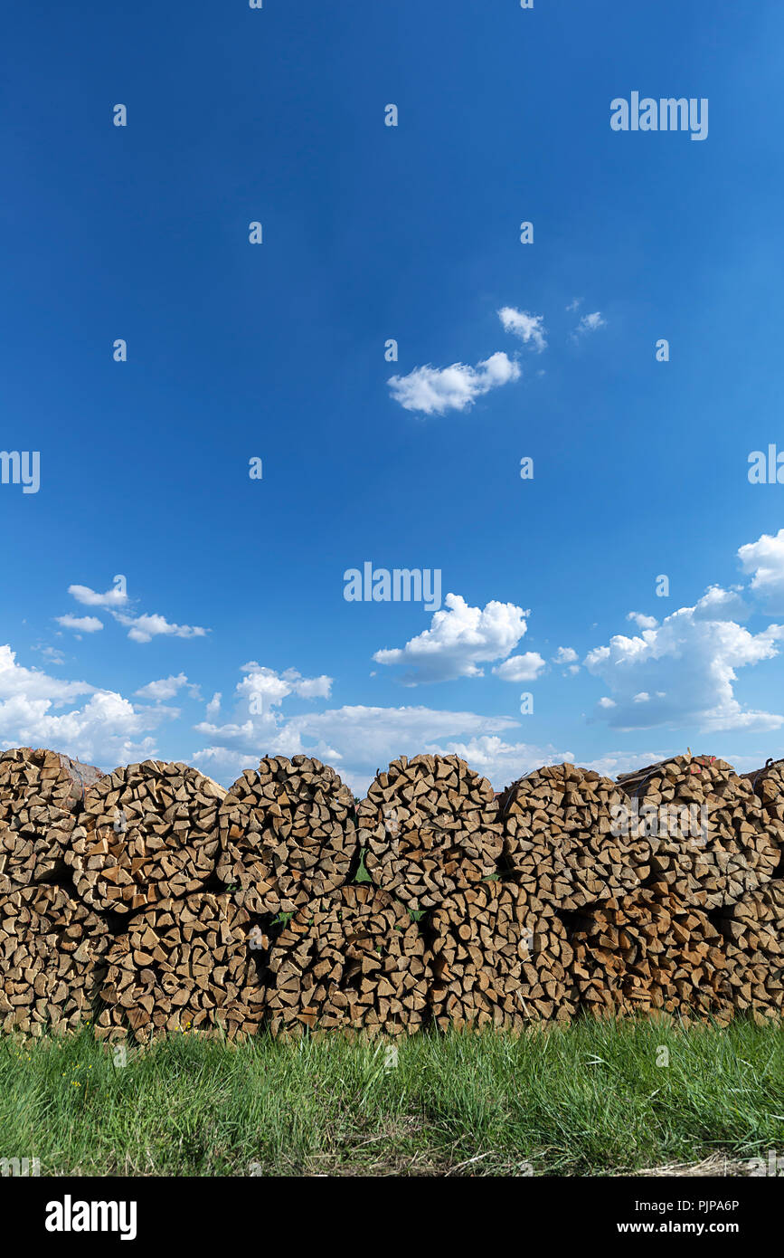 Round bunched firewood stacked, blue sky, Germany Stock Photo - Alamy