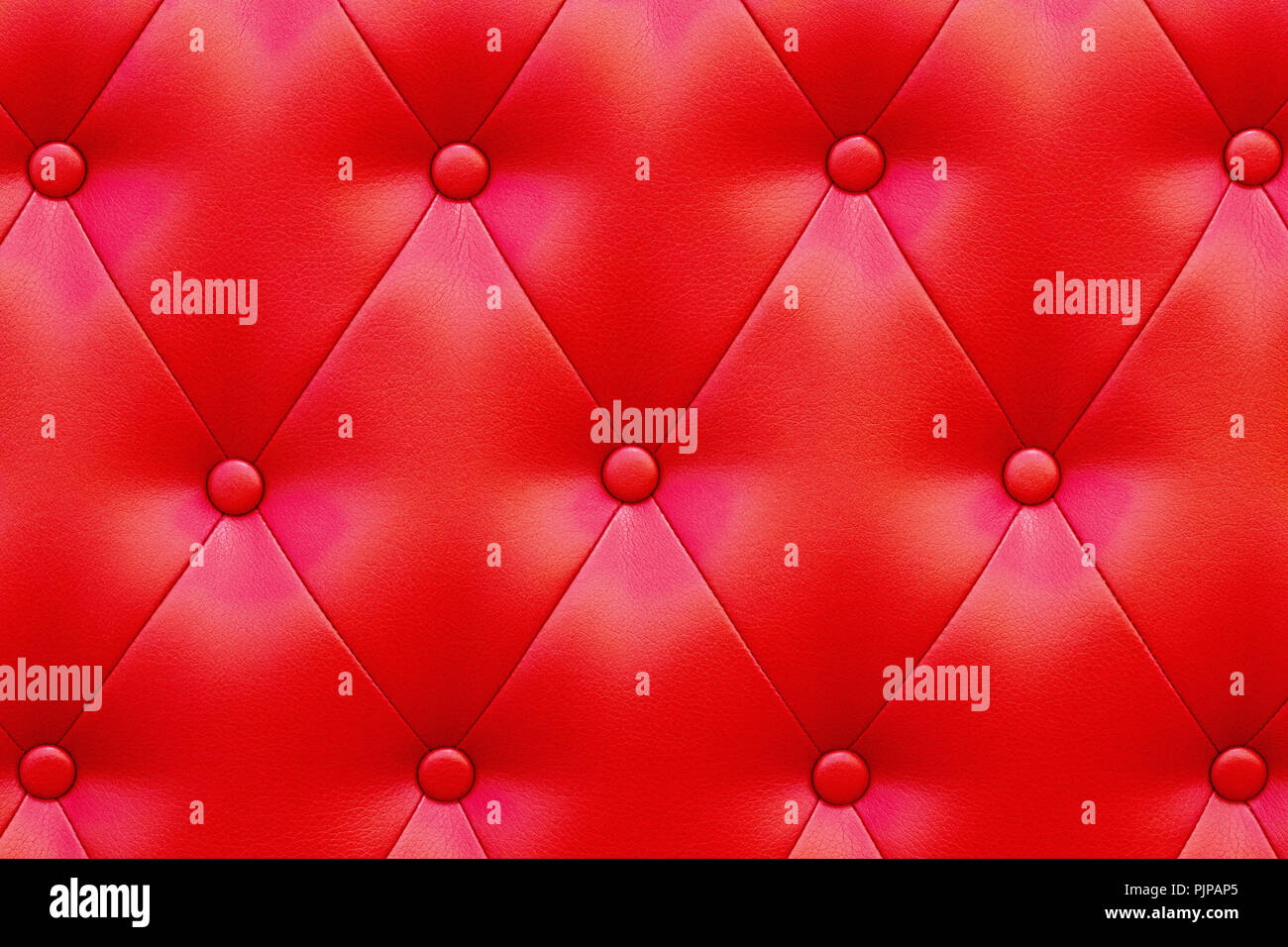 Elegant saturated glossy red leather texture of sofa chair. Stock Photo