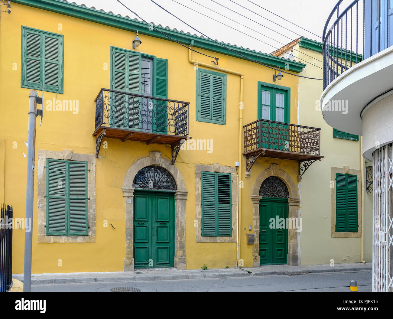 Nicosia, Cyprus - May 14, 2018: View of a typrical old house in the backstreets of Nicosia in Cyprus. Closed double doors and metal balconies. Stock Photo
