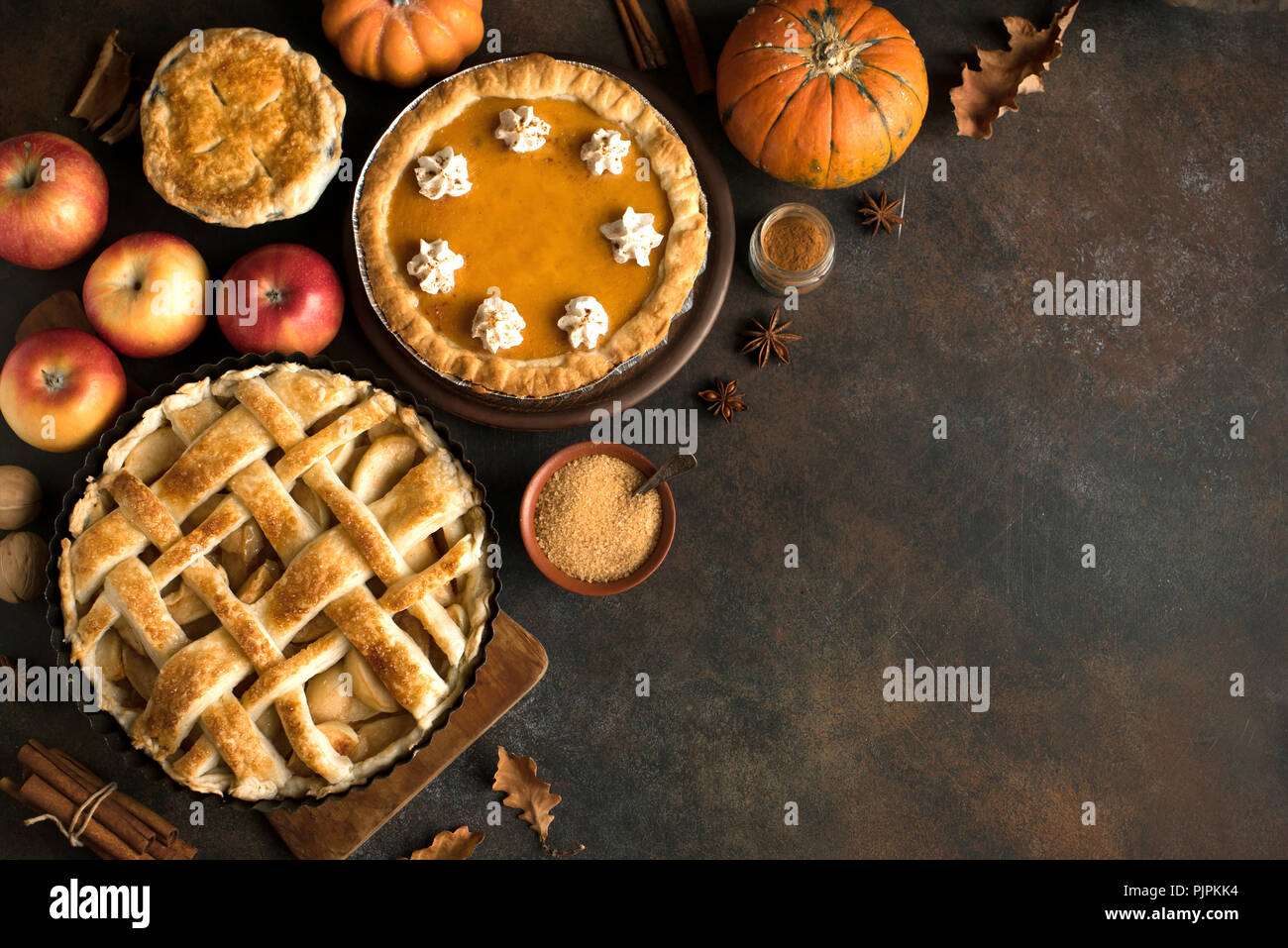 Thanksgiving pumpkin and apple various pies, top view, copy space. Fall traditional homemade apple and pumpkin pie for autumn holiday. Stock Photo