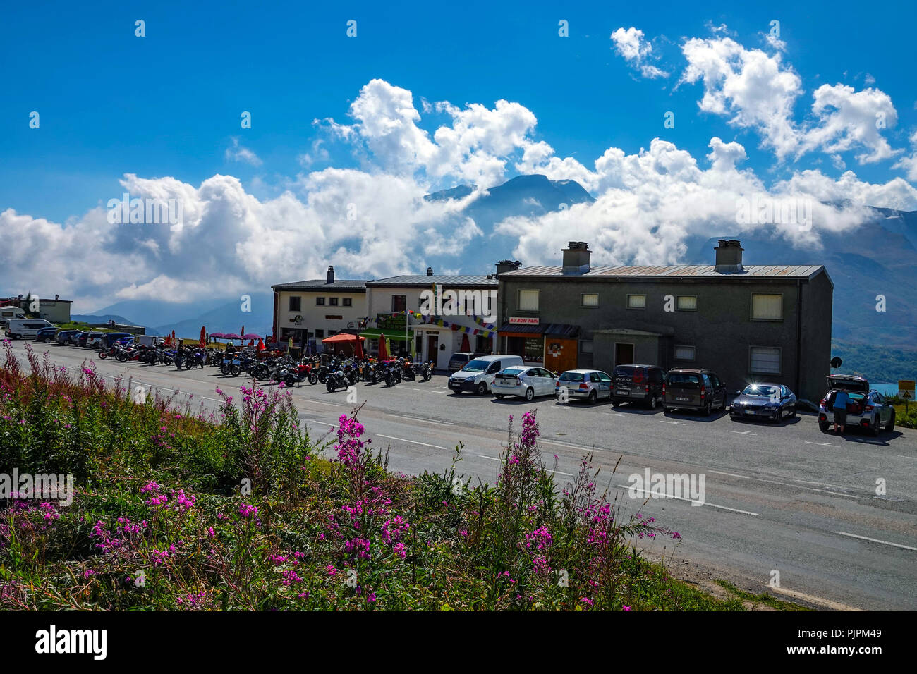 Cars and motorbikes at wayside cafe, Col de Mont Cenis mountain pass between France and Italy with large lake, reservoir, Stock Photo