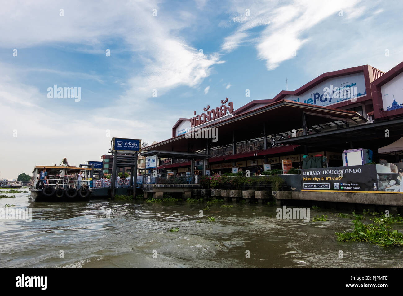 Bangkok, Thailand - 2018, May 14th: Tha Wang Land pier with docking boat and light blue sky background in the afternoon at Chao Phraya River, Bangkok, Stock Photo